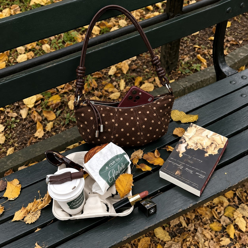 Briochelle Polka Dot Croissant Shoulder Bag - Chocolate Brown - on an autumn park bench