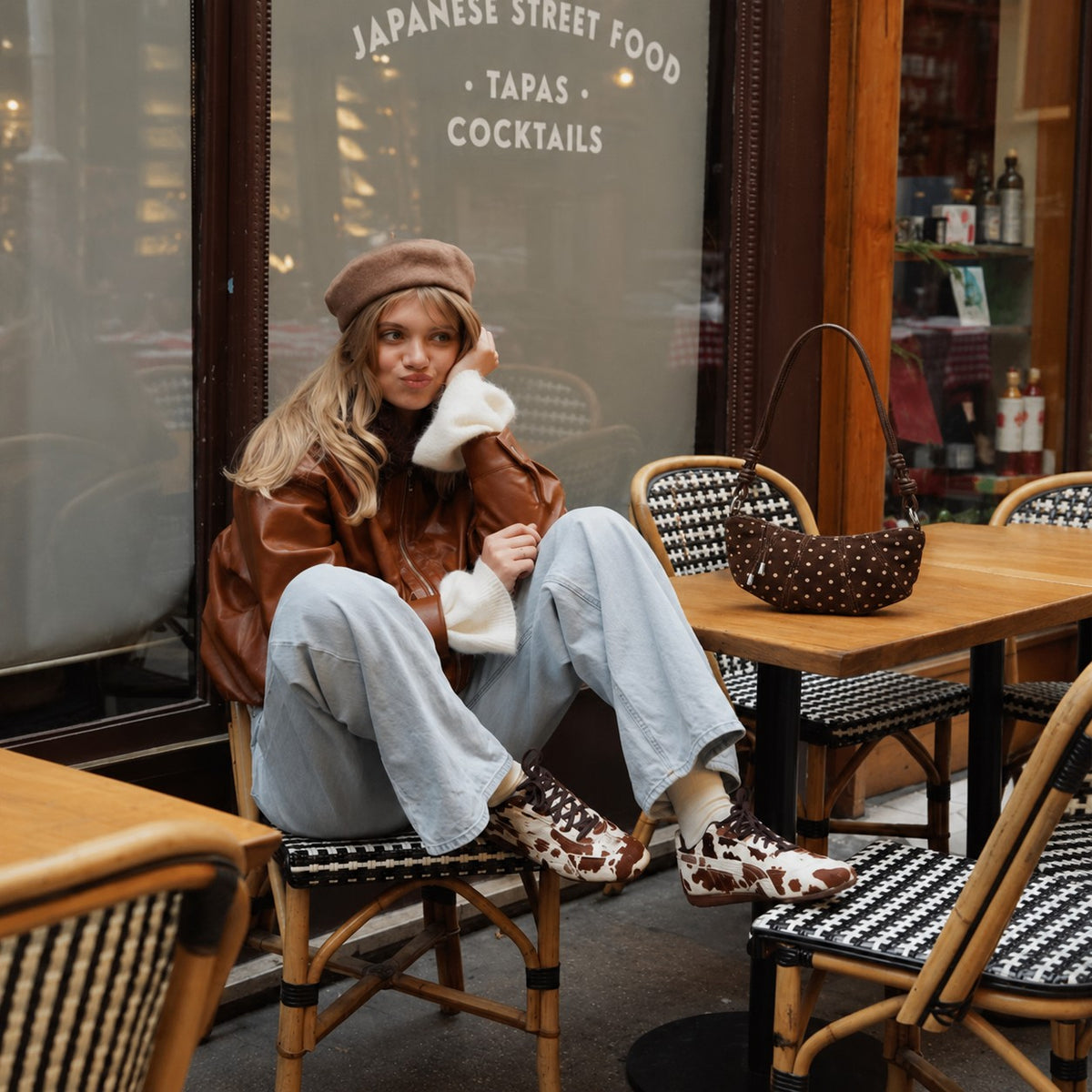 Briochelle Polka Dot Croissant Shoulder Bag - Chocolate Brown - on a cafe terrace