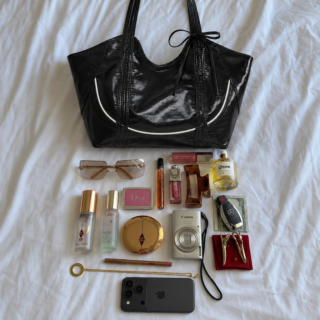 Clovara Glossy Tote Bag - Black - with everyday essentials laid out