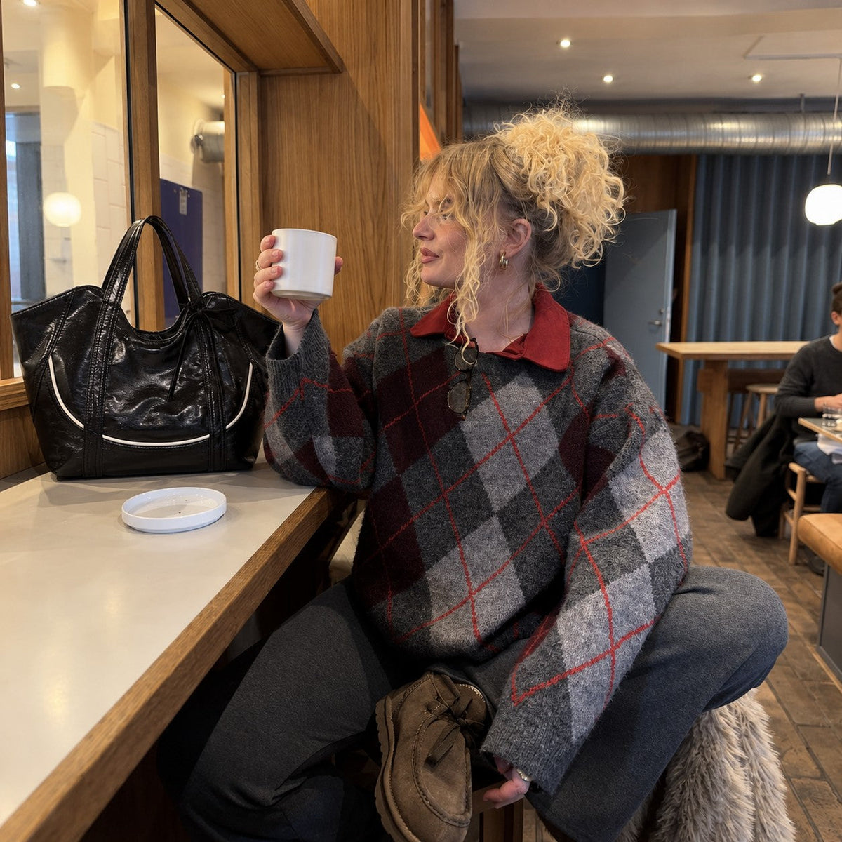 Clovara Glossy Tote Bag - Black - on a cafe counter