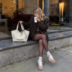 Clovara Glossy Tote Bag - White - on the lap outside a cafe