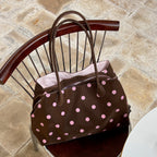 Pralinette Polka Dot Vegan Leather Shoulder Bag - resting on a chair in Brown