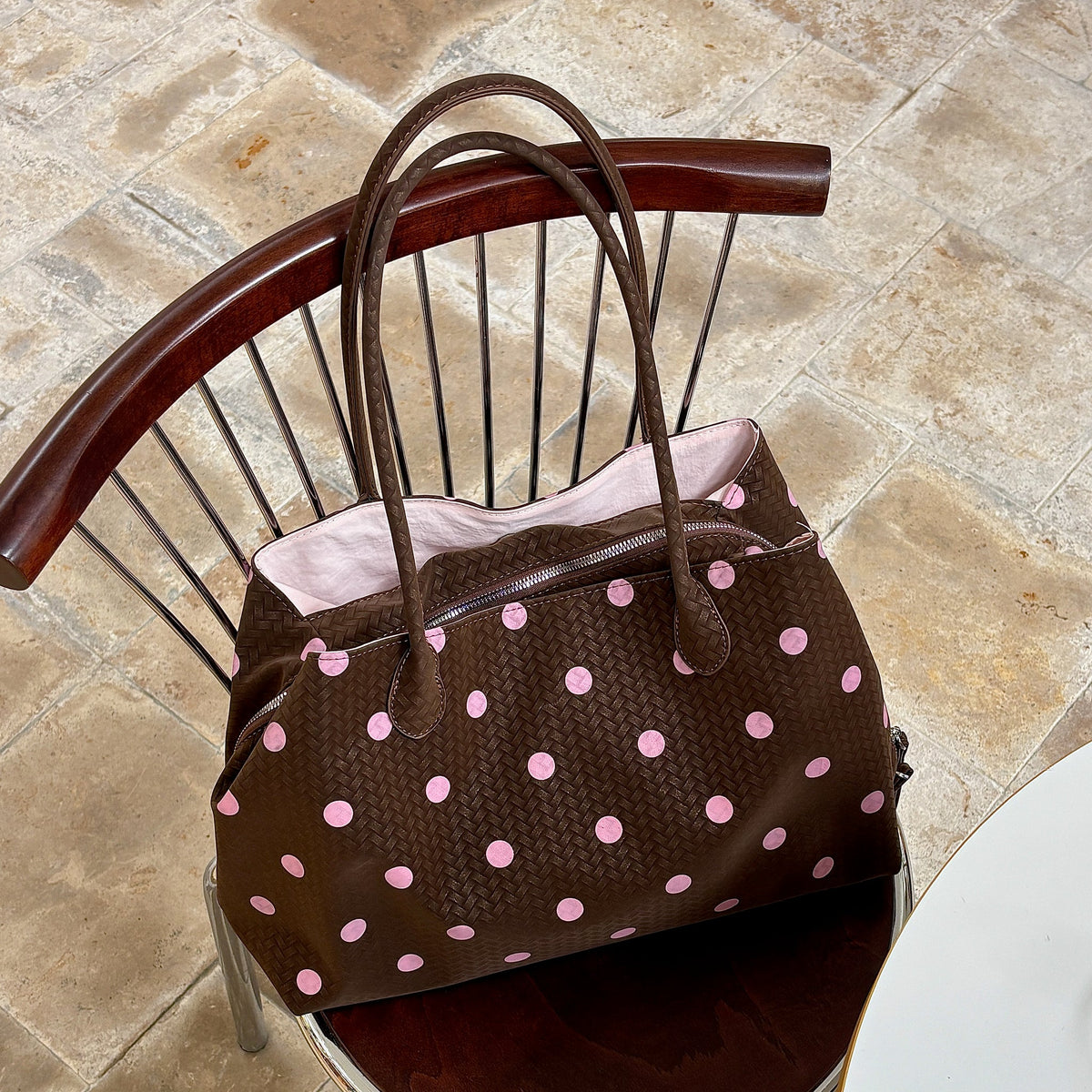 Pralinette Polka Dot Vegan Leather Shoulder Bag - resting on a chair in Brown